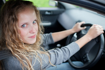 Plakat Pretty young woman driving her new car