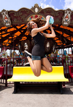 Fun girl jumping at Carousel