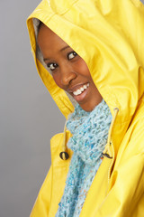 Young Woman Wearing Yellow Raincoat In Studio