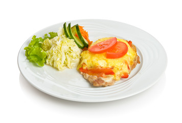Pork chop baked with cheese and vegetables with side dish.
