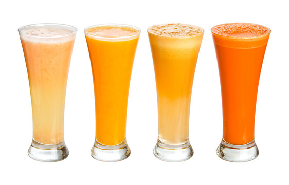 Four glasses of fresh juices. Grapefruit, orange, apple, carrot.