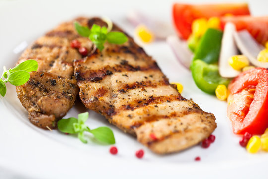 Grilled chicken breast with fresh vegetables and herbs
