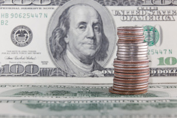 coin tower (quarters, dimes, pennies) with old hundred dollar bills background close up view
