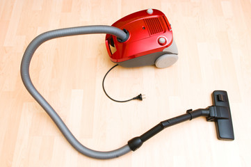 Vacuum cleaner on the wooden floor