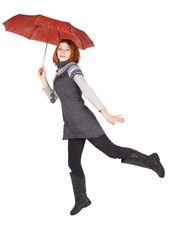 young beautiful girl in knit dress holding red umbrella and jump