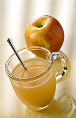 Slings Apple Toddy in a cup with a spoon and an apple