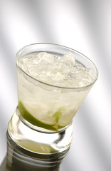 Glass of caipiriniha in front of light background