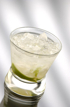 Glass of caipiriniha in front of light background
