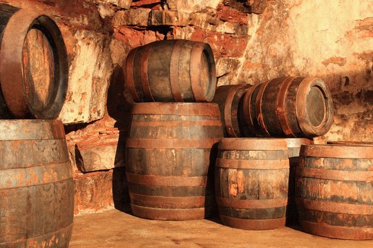 Alte Holzf&auml;sser im Kellergew&ouml;lbe gestapelt