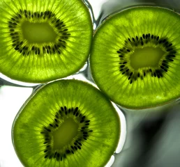Photo sur Plexiglas Anti-reflet Tranches de fruits Kiwi sur la surface mouillée