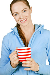 Beautiful young smiling woman holding a cup of coffee or tea