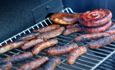 Würstchen-Schnecken und Bratwürstchen auf dem Grill