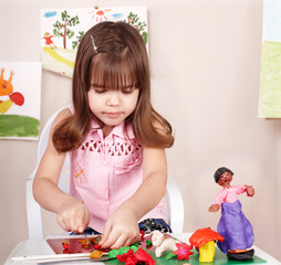 Child playing with plasticine in school.