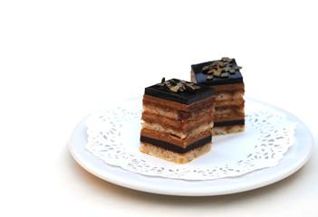 Fine chocolate cakes on plate, on white, shallow dof