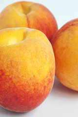Fototapeta na wymiar Closeup of three peaches in a row isolated on white