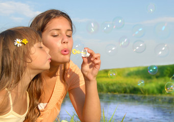 Siblings blowing soap bubbles