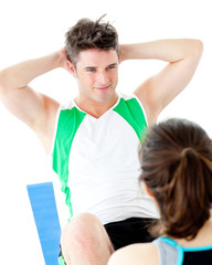 Obraz premium Handsome man doing fitness exercises with a woman