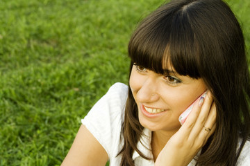 Young beautiful woman on the phone in the park.