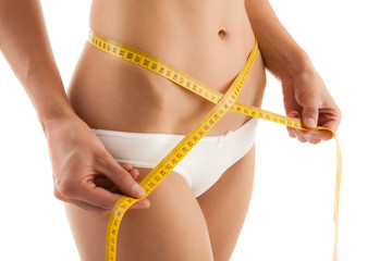 Woman measuring her slim body isolated on white