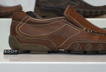 Fototapeta na wymiar Mens leather shoes on display in window