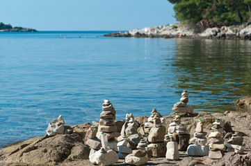 Stone pyramids at the seaside. Adriatic shore