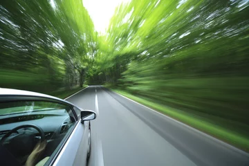 Keuken foto achterwand Snelle auto auto rijdt snel het bos in.