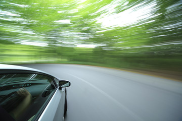 Obraz na płótnie Canvas car driving fast into forest