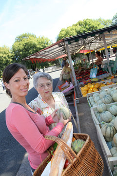 Young woman helping elderly woman with grocery shopping
