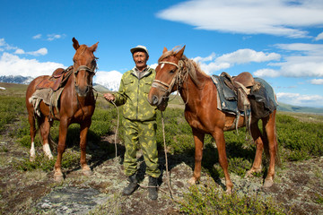 Asian man holding two horses