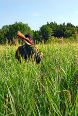 Hunter walking through the high grass
