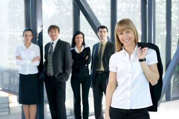 A group of four young business persons in a modern office