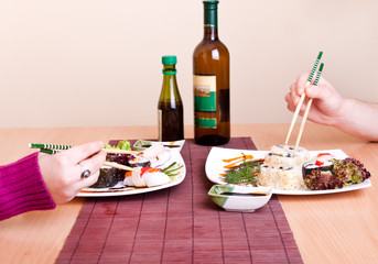 two persons eating sushi