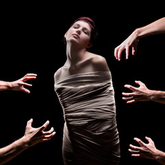 Hands about to grab a female wrapped in a bandage