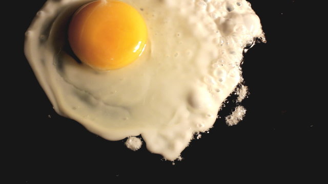 fried egg on black pan - timelapse