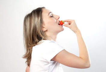 femme de profil mangeant une fraise