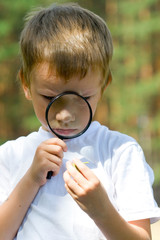 Happy boy with a magnifying glass