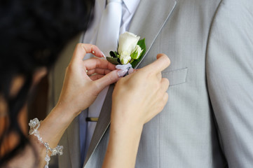 Bride adjusting groom's boutonniere