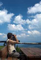 Górski turysta obserwujący panoramę gór przez lornetkę