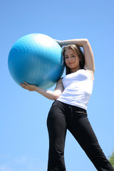 Fototapeta premium Young woman doing yoga exercises with the ball