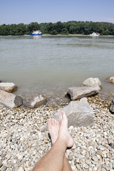 Donau river with boat and feet