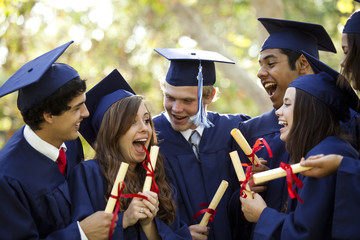 Graduating students smiling and laughing with diplomas - obrazy, fototapety, plakaty