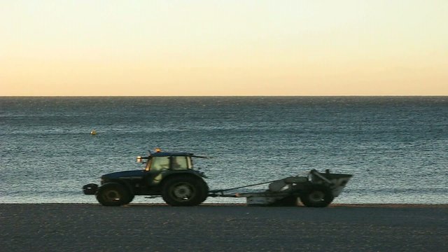 TRACTORISTA LIMPIANDO LA PLAYA AL AMANECER