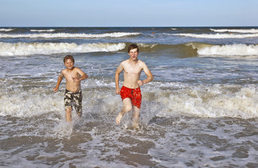 boys running along the beach