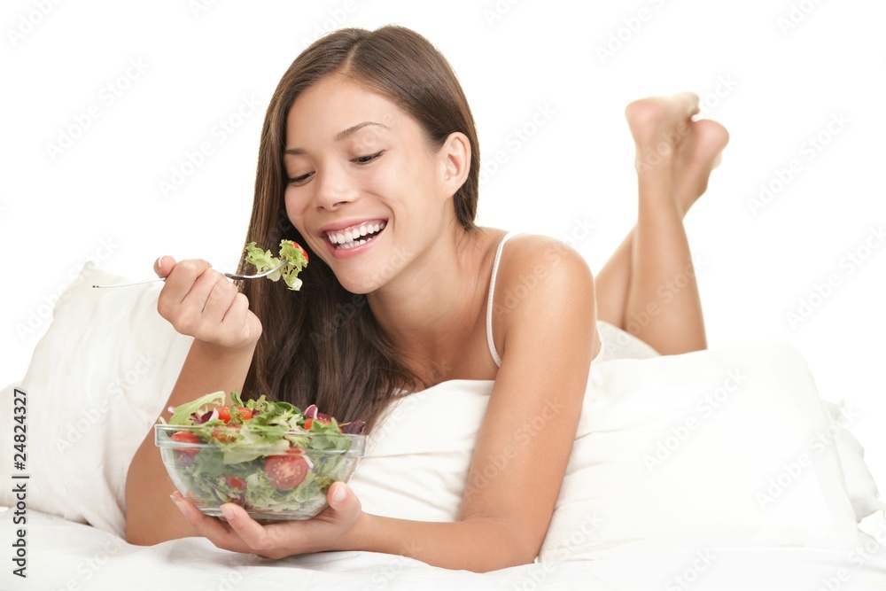 Wall mural Healthy woman eating salad in bed