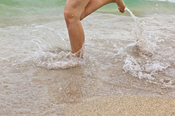 feet of boy running along the beach