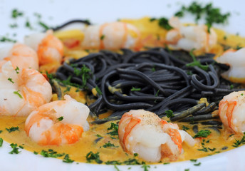 Scampi with inkfish pasta and curry sauce, shallow dof