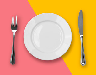 Knife, plate and fork on colorful background
