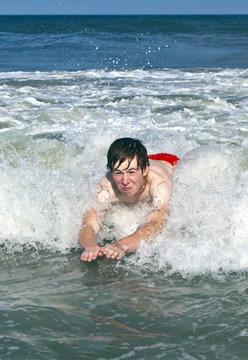 young boy is bodysurfing in the waves