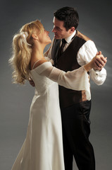 Portrait of the young happy newlyweds on dark background