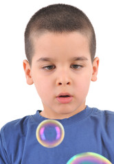 Little boy blowing soap bubbles.